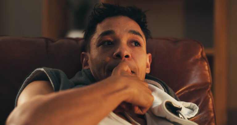 Drugs, addiction and man on sofa with stress, biting nails and withdrawal symptom in home at night Drugs, addiction and man on sofa with stress, biting nails and withdrawal symptom in home at night