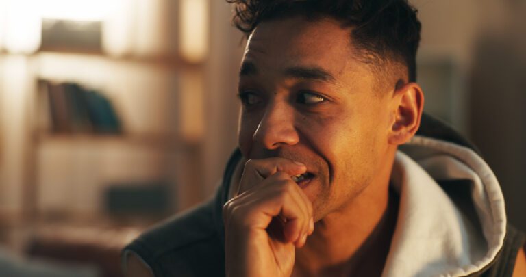 Drugs, addiction and man in home with stress, biting nails and withdrawal symptoms at night Drugs, addiction and man in home with stress, biting nails and withdrawal symptoms at night